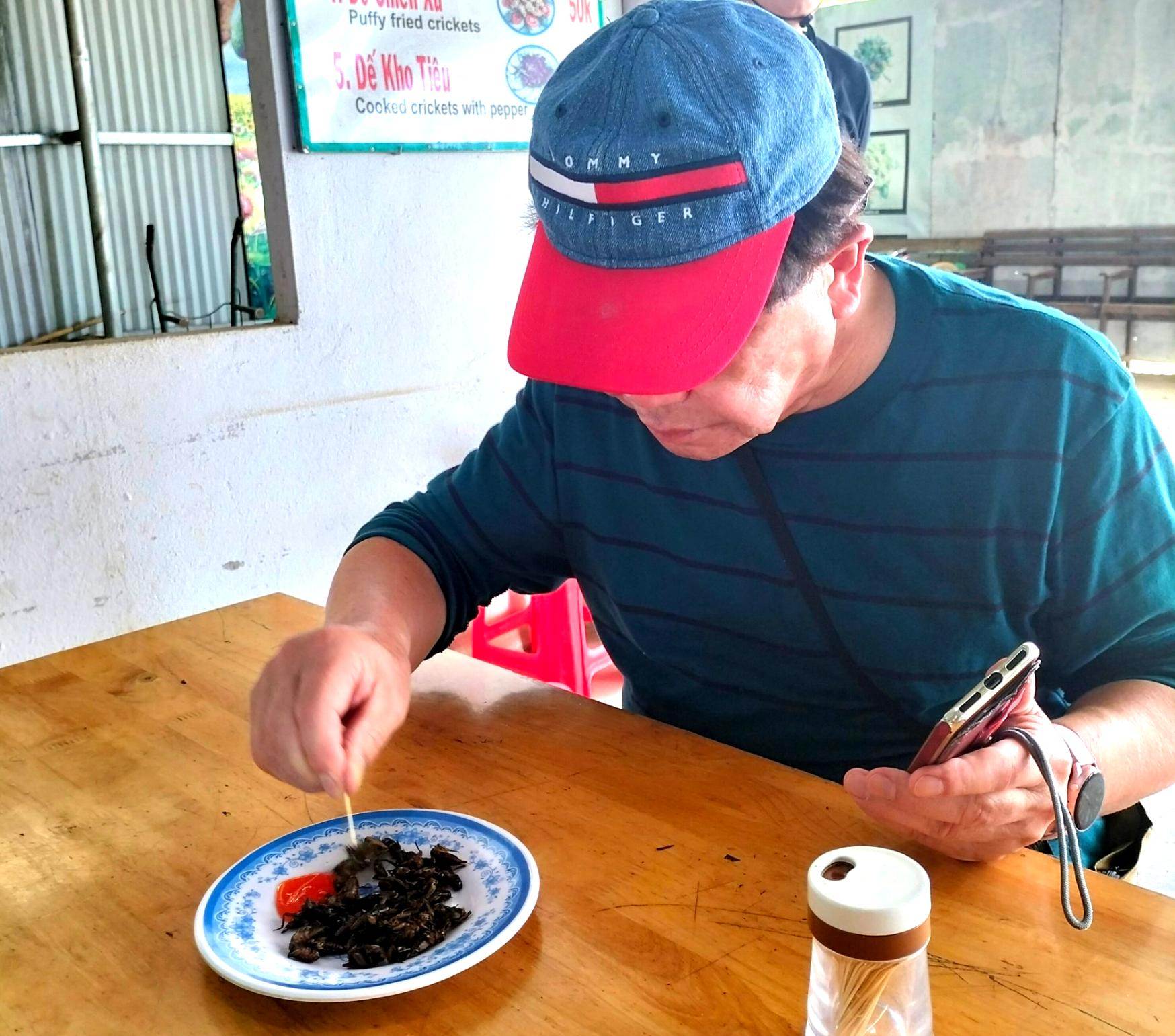 A tourist tasting crickets